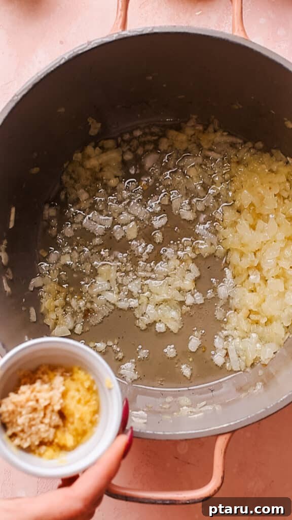 Simple Creamy Paneer Malai Kofta Curry 7 Sautéing onions, garlic, and ginger in a pan for the Malai Kofta gravy base.