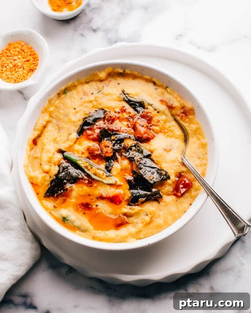 Vibrant Indian Vegetarian Dinner Ideas 3 Masoor dal (red lentil curry) with tarka in a bowl with a spoon.