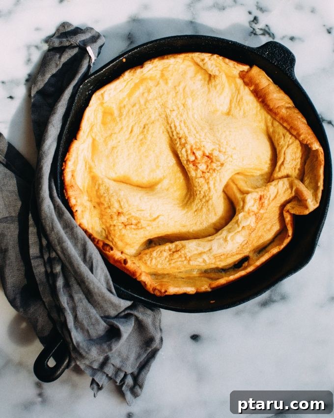 Tangy Rhubarb Skillet Puff 3 Another view of Dutch Baby pancakes, one showcasing its fluffy texture with a side of rhubarb curd