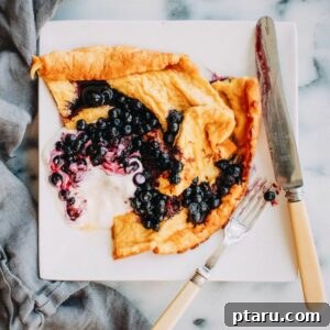 Close-up of a freshly baked Rhubarb Dutch Baby pancake, golden brown and perfectly puffed