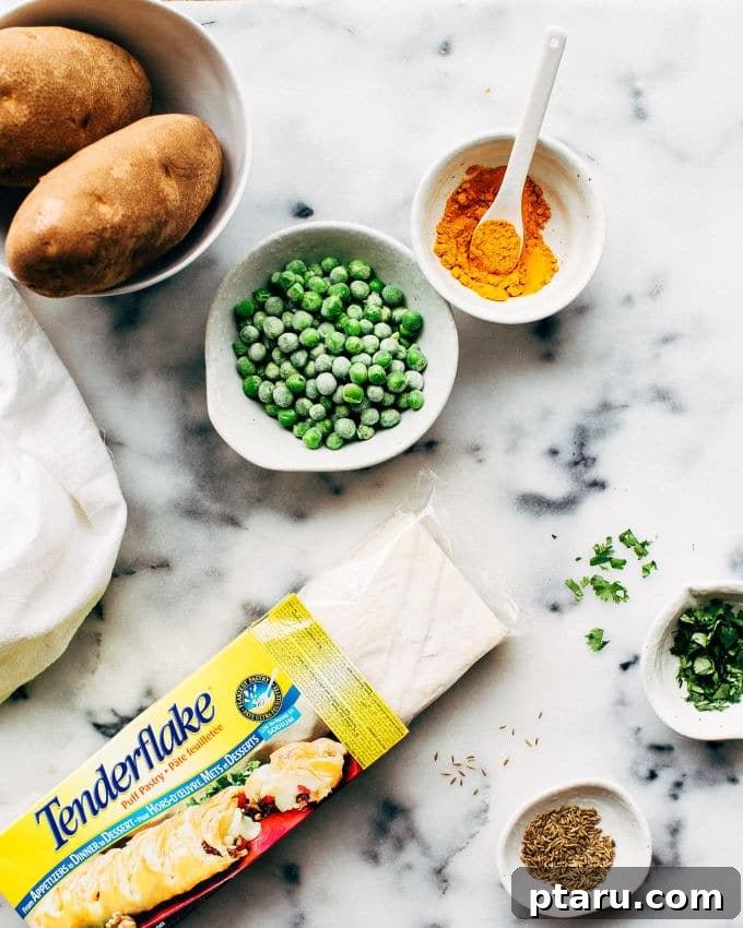 Effortless Flaky Samosas 4 Uncooked puff pastry samosas filled with spiced potato and peas, ready for baking