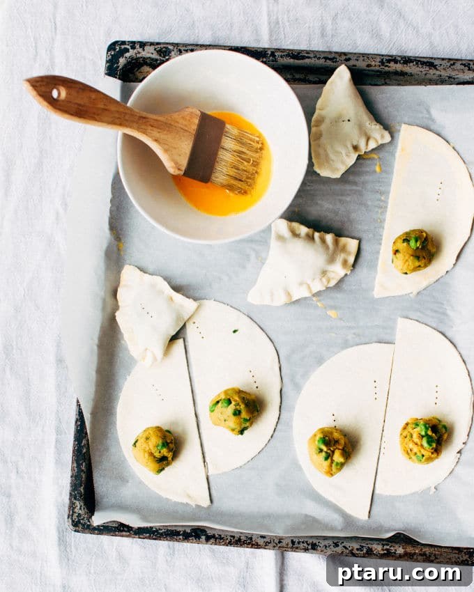 Effortless Flaky Samosas 9 Brushing assembled puff pastry samosas with egg wash before baking