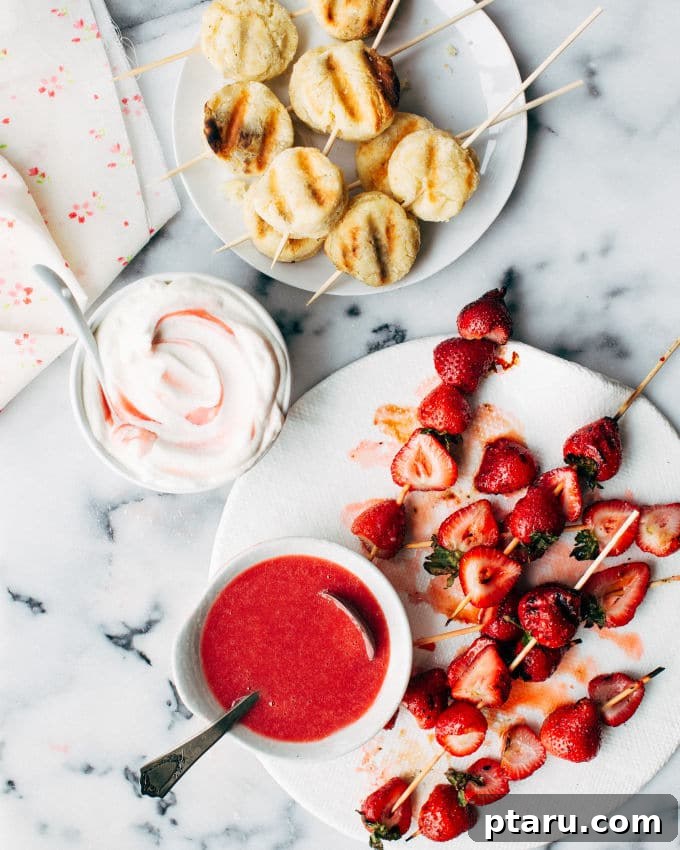 Close-up of freshly grilled strawberry and biscuit kebabs on a wooden board.