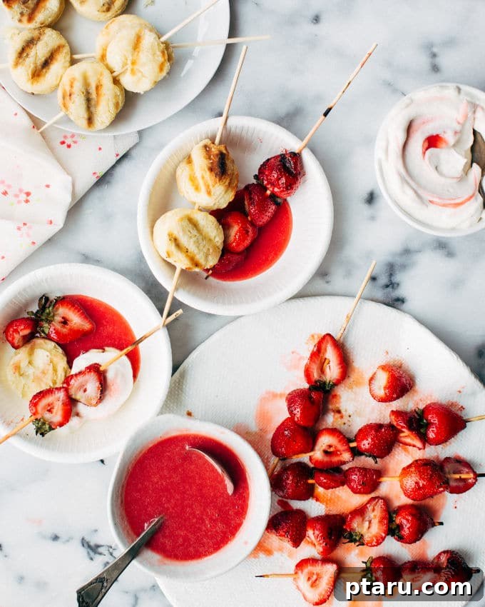 Close-up view of grilled biscuits with distinct grill marks alongside softened, charred grilled strawberries.