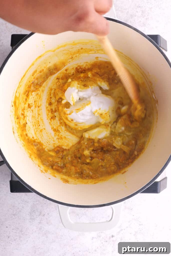 Fiery Goan Pork Vindaloo 6 Coconut milk being stirred into the Vindaloo curry sauce.