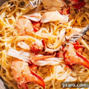 Lobster Pasta Recipe in a pan with tongs, showcasing a vibrant and rich dish.