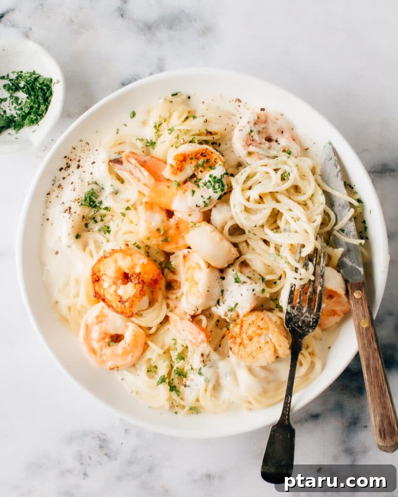 Beyond Basic The Webs Most Unique Pasta Creations 12 Elegant seafood pasta featuring a rich cream sauce on a plate, served with a fork and knife.