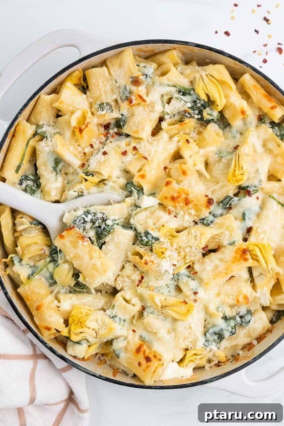 Beyond Basic The Webs Most Unique Pasta Creations 17 Creamy artichoke and spinach pasta bake, golden brown and bubbling in a casserole dish.