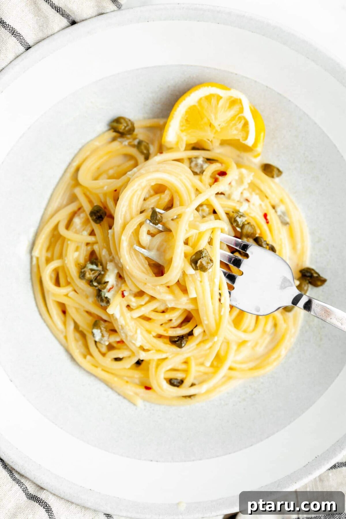 Beyond Basic The Webs Most Unique Pasta Creations 19 Pasta adorned with crispy capers, fresh lemon wedges, and green herbs.