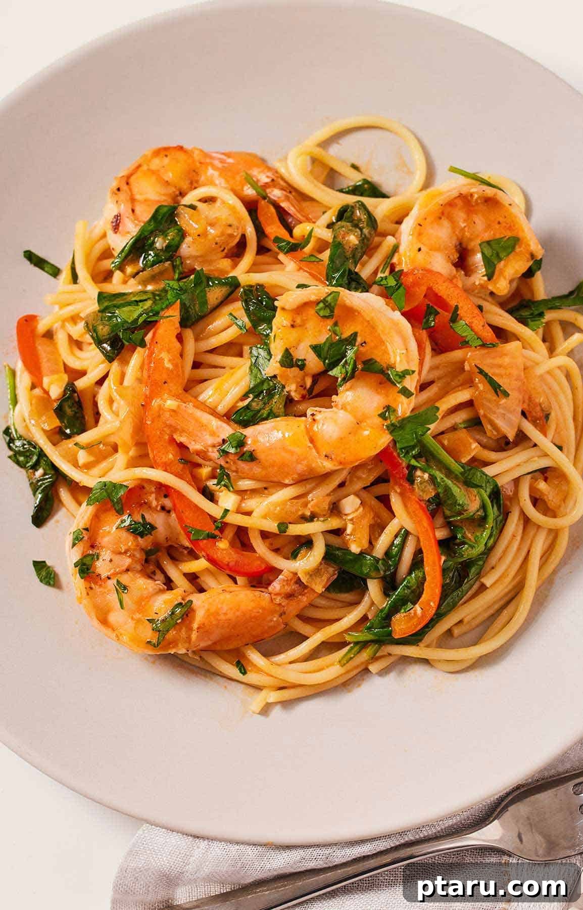 Beyond Basic The Webs Most Unique Pasta Creations 20 Red curry pasta featuring plump shrimp and vibrant fresh cilantro, in a deep bowl.