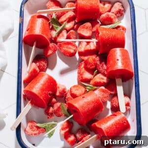 Strawberry popsicles on a tray, highlighting their vibrant color and refreshing appeal.