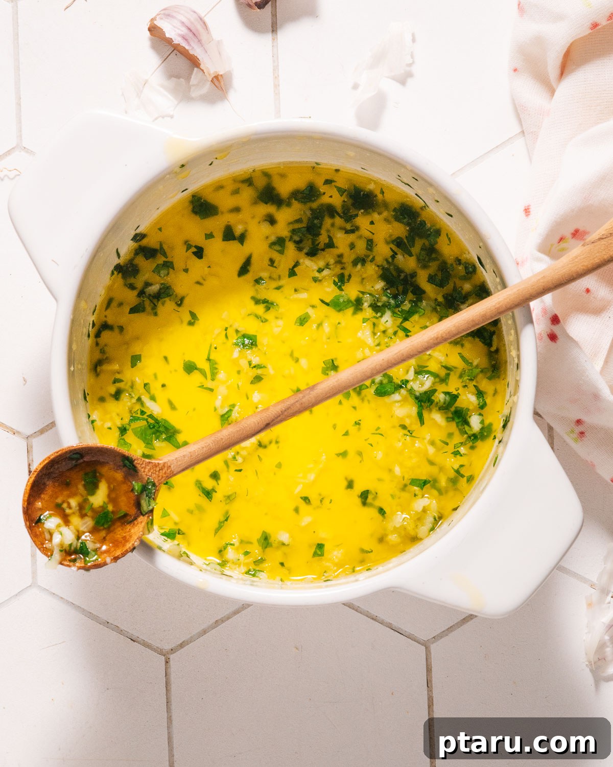 Speedy Three Ingredient Garlic Butter 2 A golden Garlic Butter Sauce in a pot, ready to be served, with a spoon dipping in it.