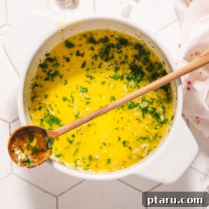 Speedy Three Ingredient Garlic Butter 7 Garlic Butter Sauce with a spoon in a pot, ready to be served.