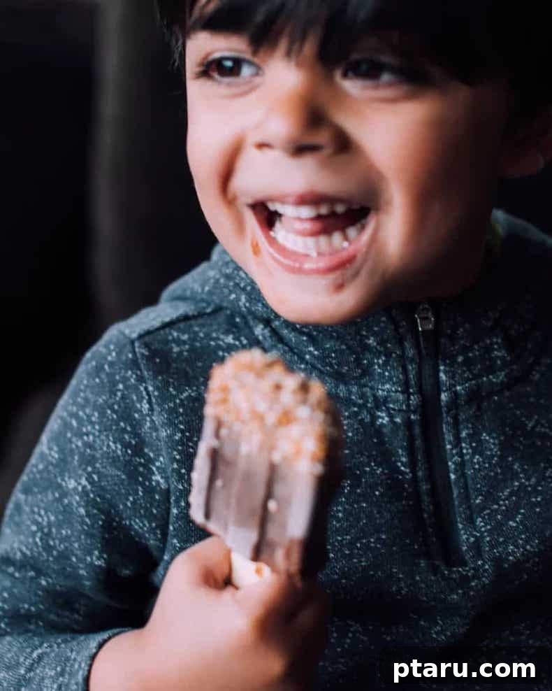 Two healthy fudgesicles on a wooden board, one with coconut sprinkles