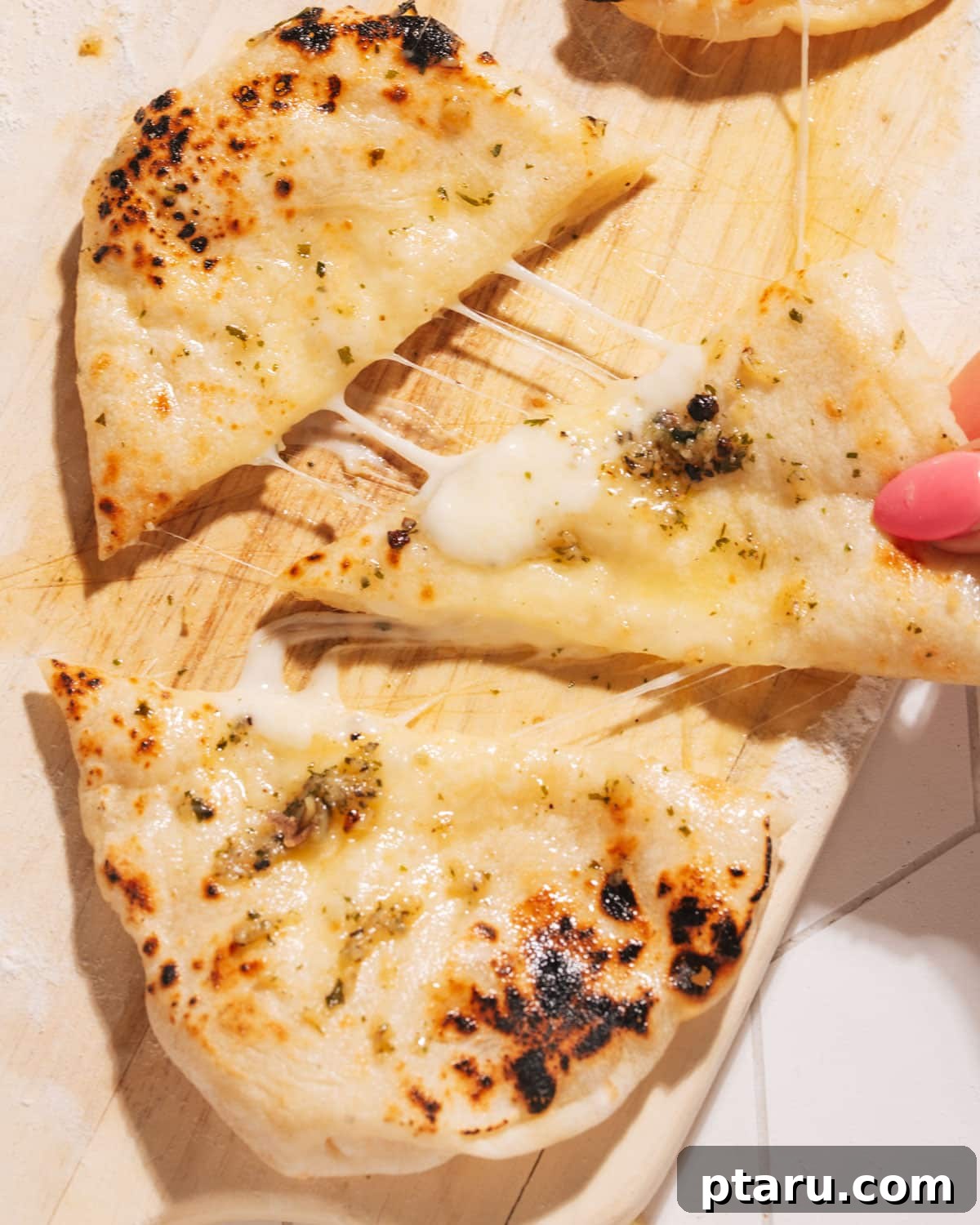 Gooey Cheese Naan 7 Cheese Naan being pulled apart.