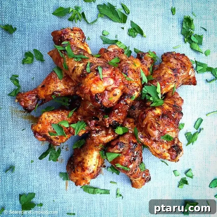 Grilled Wings Perfected 10 Crispy Recipes 7 Glossy Asian Glazed Chicken Wings garnished with fresh herbs.