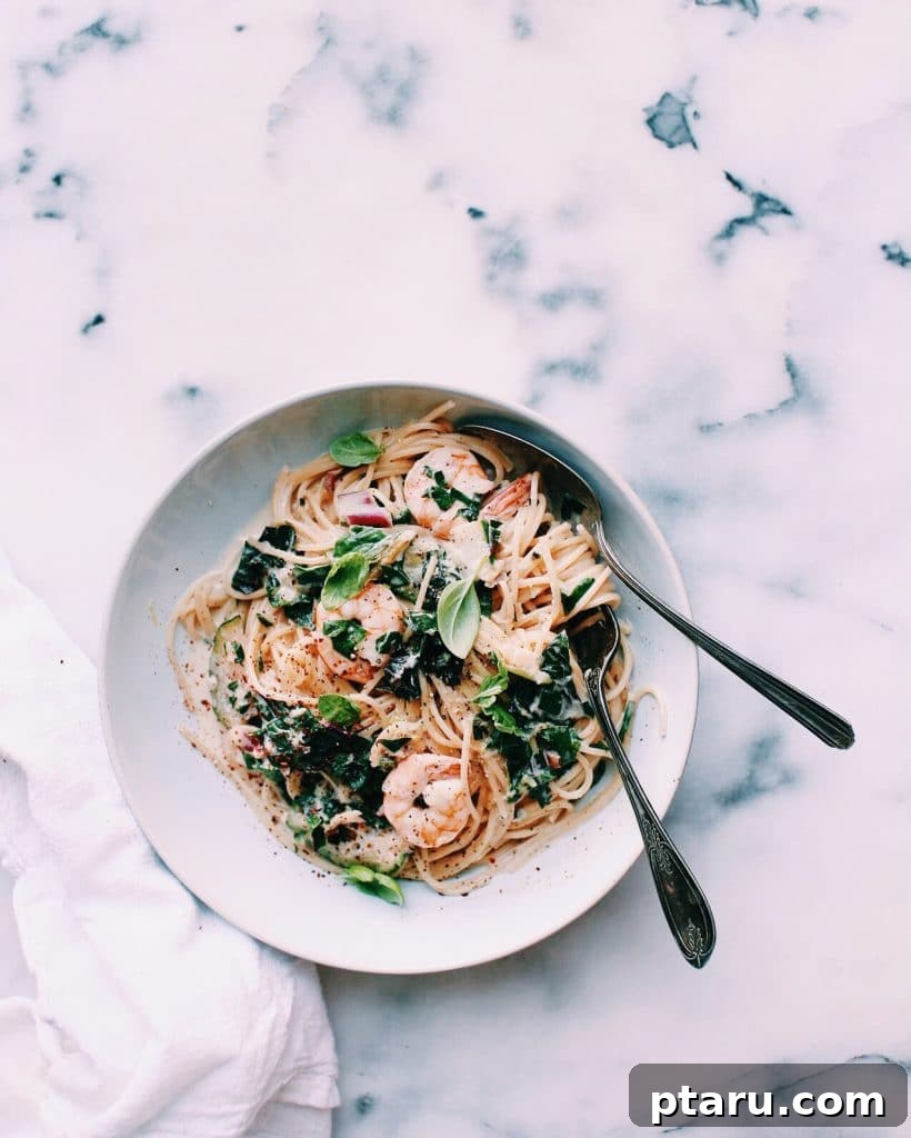 20+ Guilt-Free Shrimp Recipes for Dinner: Absolutely Delicious! 7 Shrimp Alfredo with Chard and Zucchini, garnished with fresh basil.