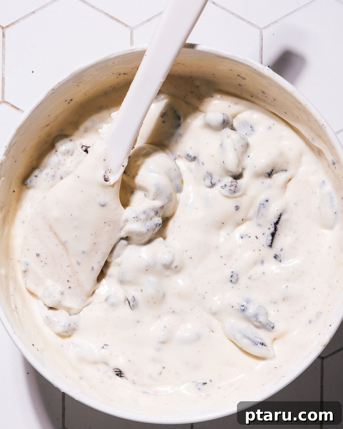 Effortless No-Churn Cookies and Cream Delight 7 Mixing the cookies into the cookies and cream ice cream mixture.