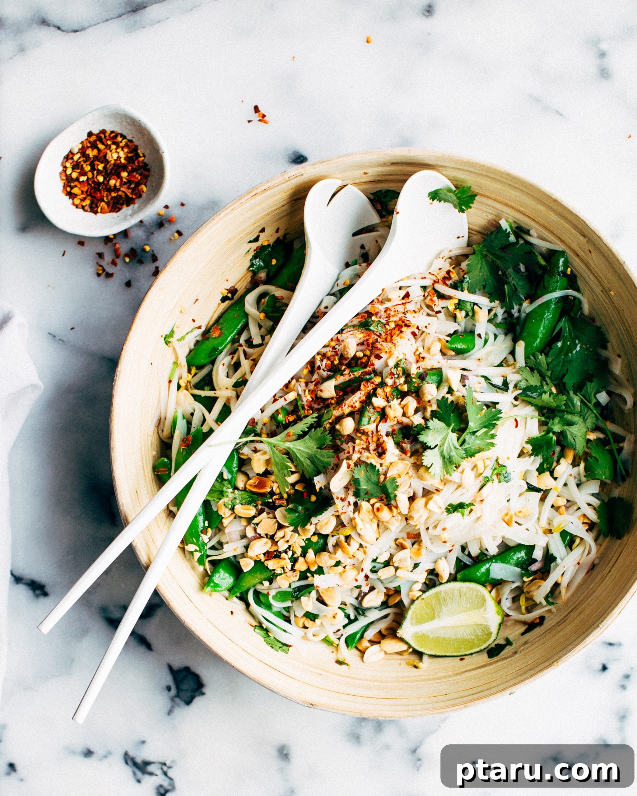 Sweet Heat Thai Noodle Salad 2 Delicious Thai noodle salad in a bowl, garnished with fresh herbs and peanuts