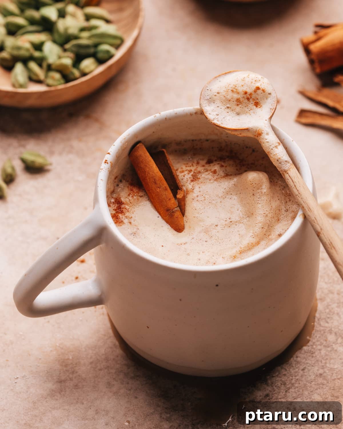 The Ultimate Guide to Indian Beverage Recipes 5 Chai Coffee in a pristine white cup with a spoon, highlighting its creamy texture.