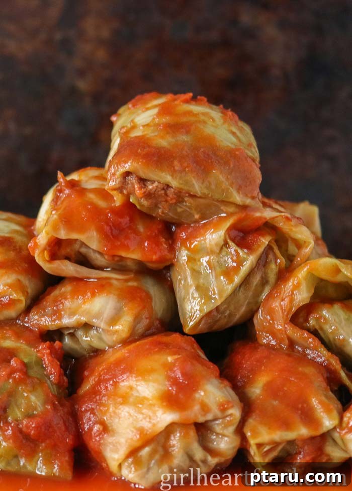 The Ultimate Ground Beef and Cabbage Recipe Collection 7 Platter of traditional Easy Cabbage Rolls, drenched in sauce.