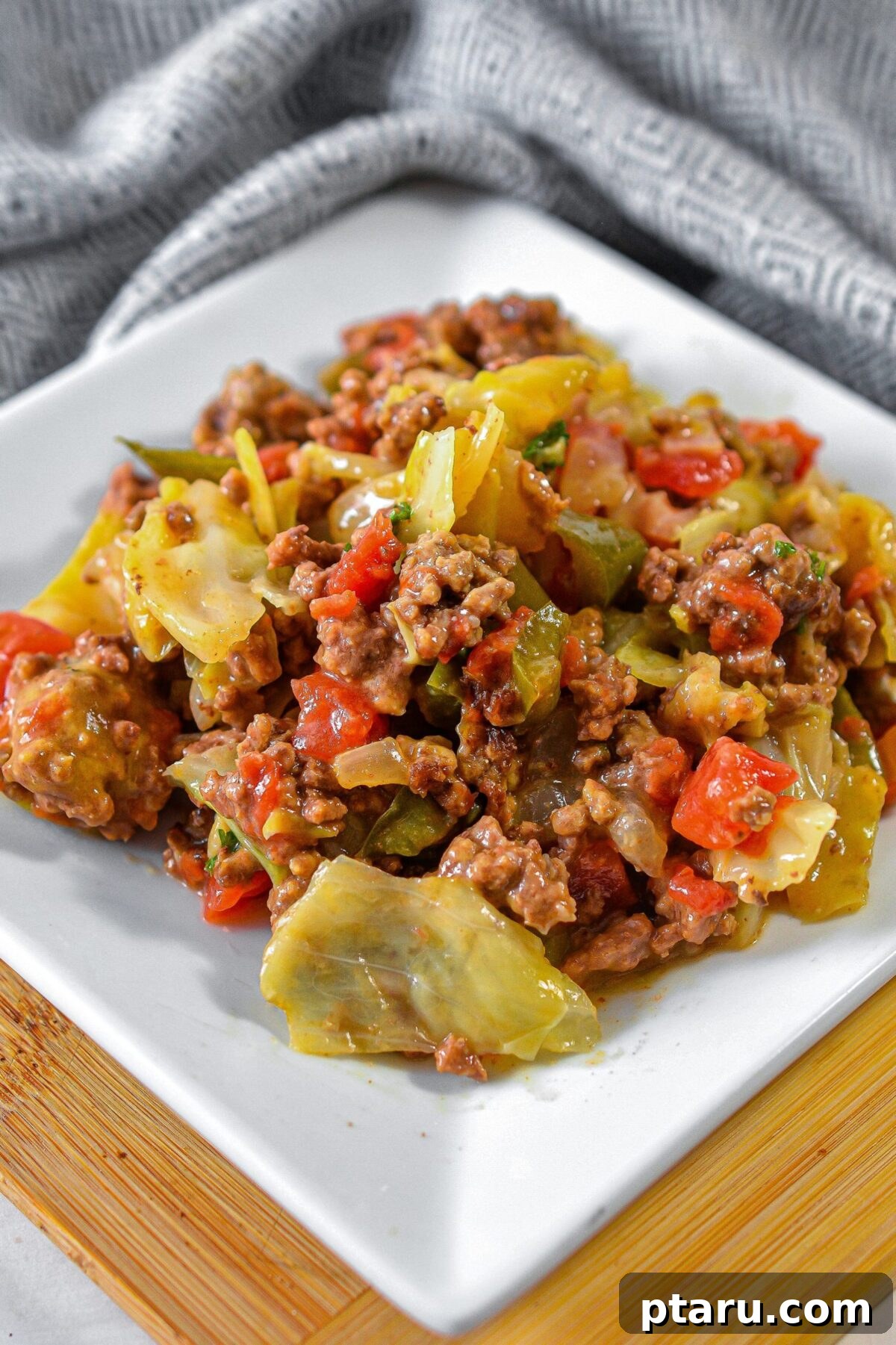 The Ultimate Ground Beef and Cabbage Recipe Collection 8 A close-up of a bubbling Cheesy Beef and Cabbage Skillet, garnished with fresh herbs.