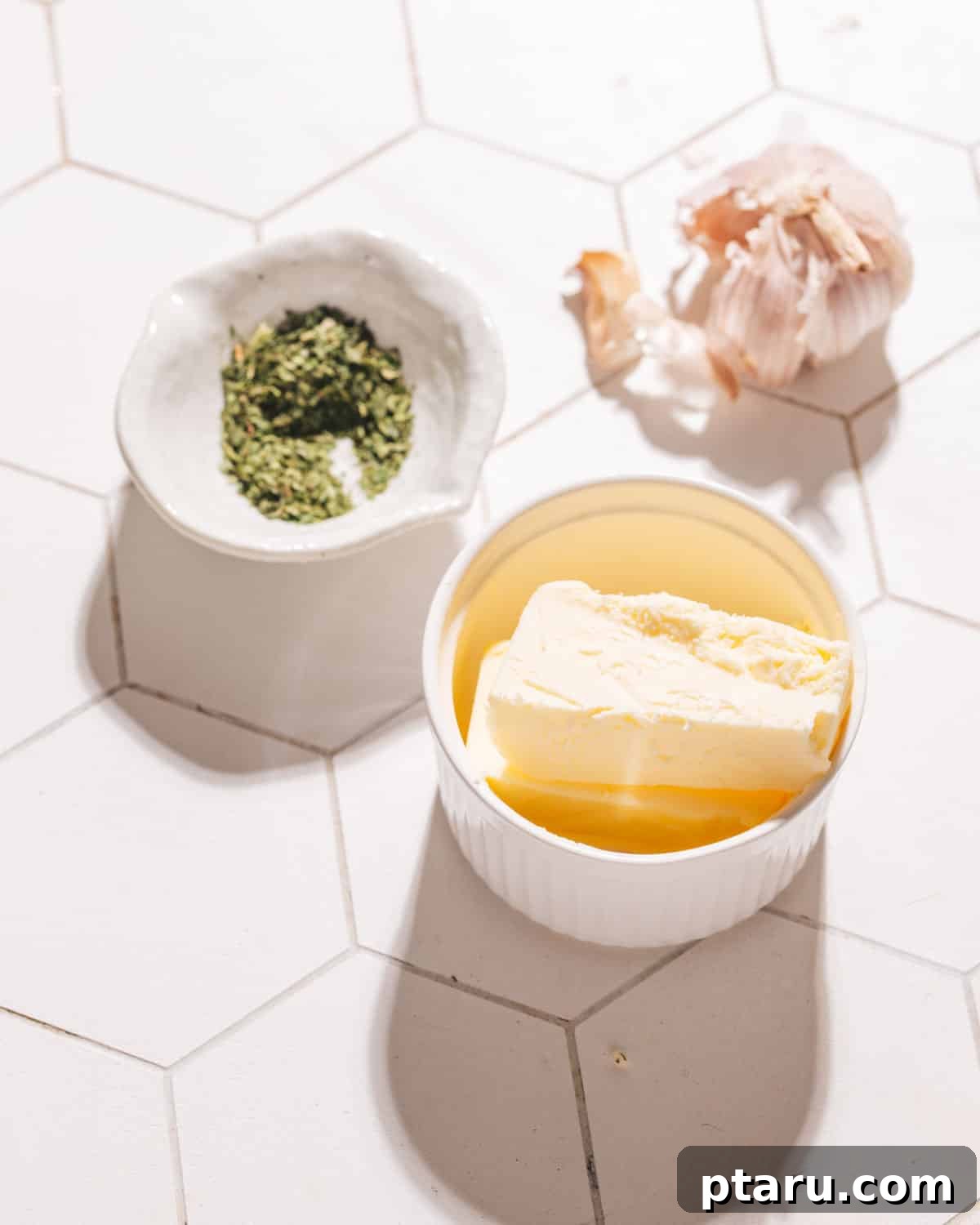 Homemade Garlic Bread That Outshines Restaurants 4 Close-up of fresh garlic cloves, softened butter, and chopped parsley – core ingredients for perfect garlic bread.