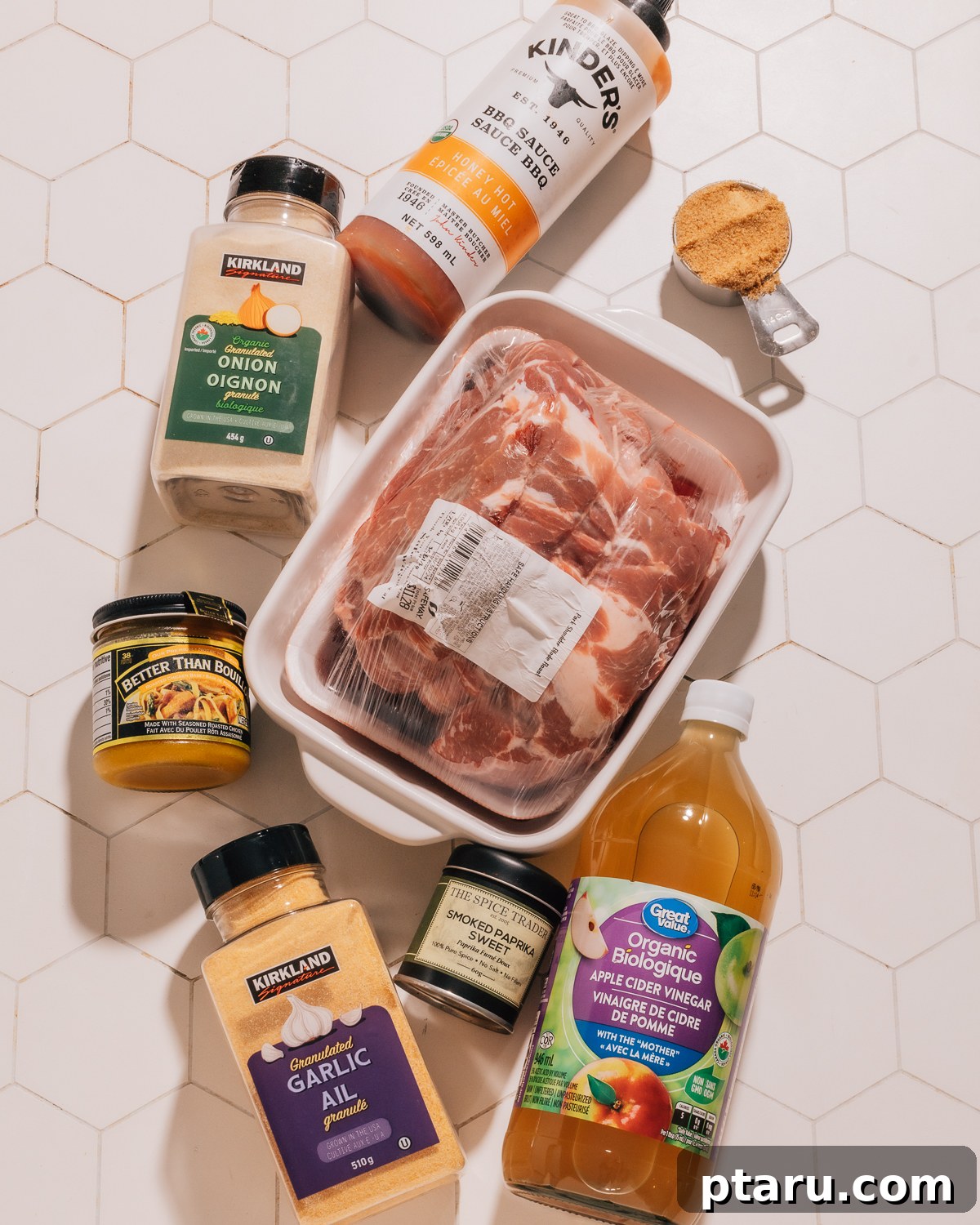 Effortless Instant Pot Fall-Apart Pulled Pork 3 A flat lay image showing all the essential ingredients for Instant Pot Pulled Pork: pork shoulder, various spices, chicken broth, apple cider vinegar, and brown sugar.