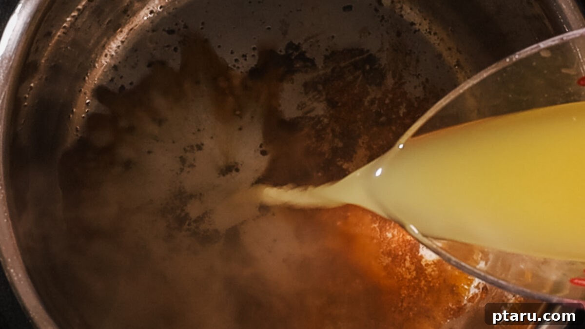 Effortless Instant Pot Fall-Apart Pulled Pork 6 Step 3: Deglazing the Instant Pot with broth and vinegar, scraping up flavorful browned bits from the bottom.