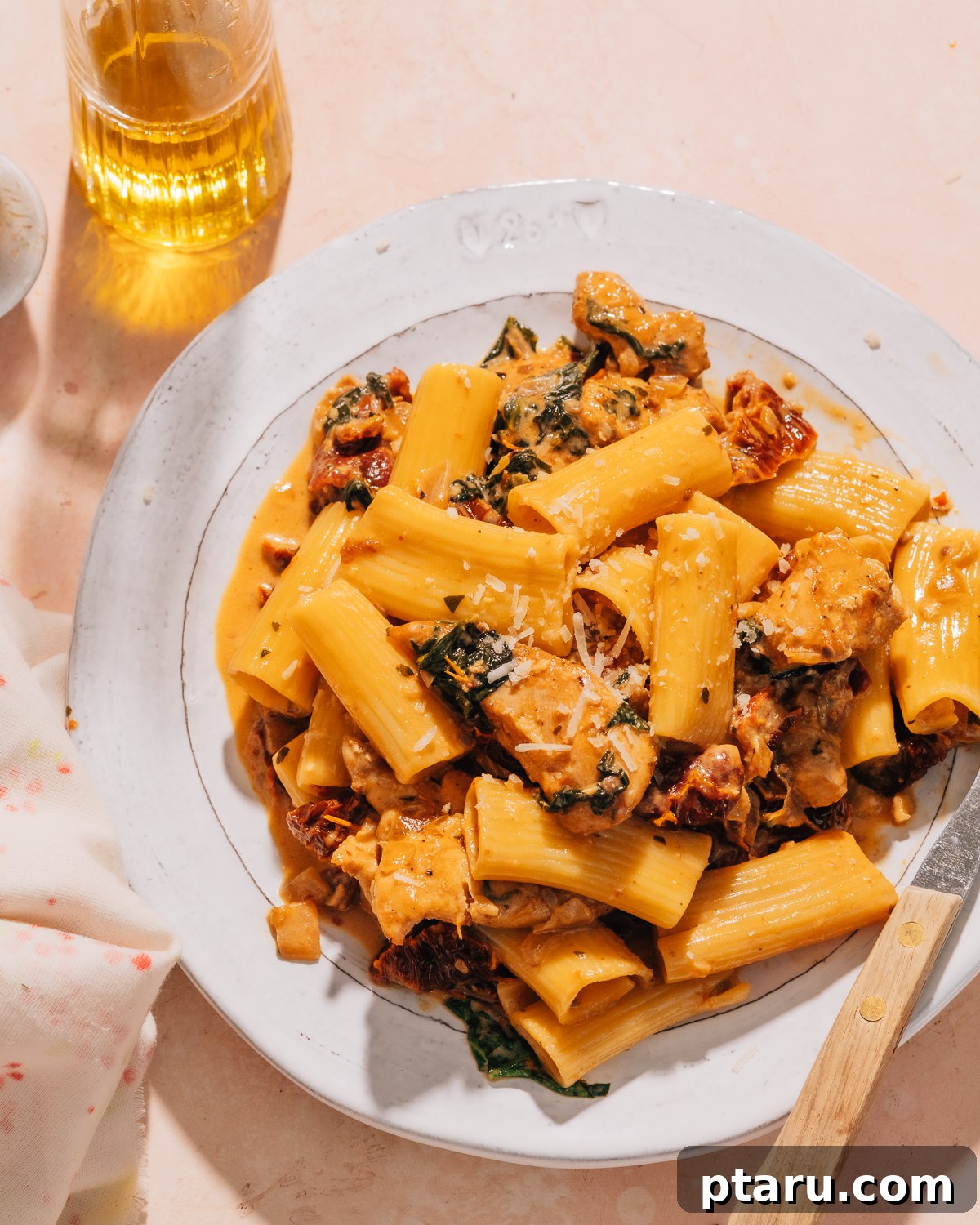 Rustic Tuscan Chicken Pasta 7 A plate of Tuscan Chicken Pasta, garnished with fresh basil, ready to be eaten.