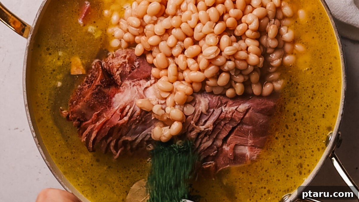 Effortless Ham and Bean Soup: Seriously Delicious and Satisfying 6 Step 3: Pouring chicken broth into the pot with beans and seasonings.