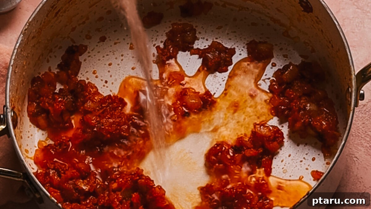30 Minute One Pot Creamy Tortellini Soup 6 Step 3: Pouring broth into the pot, stirring to combine all ingredients.