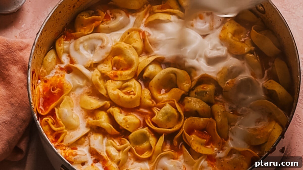 30 Minute One Pot Creamy Tortellini Soup 8 Step 5: Stirring in heavy cream and fresh baby spinach.