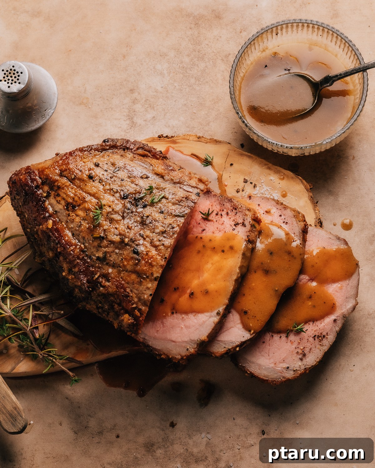 Melt-in-Your-Mouth Eye of Round Roast 9 Sliced Eye of Round Roast served on a white plate with fresh herbs and rich gravy.
