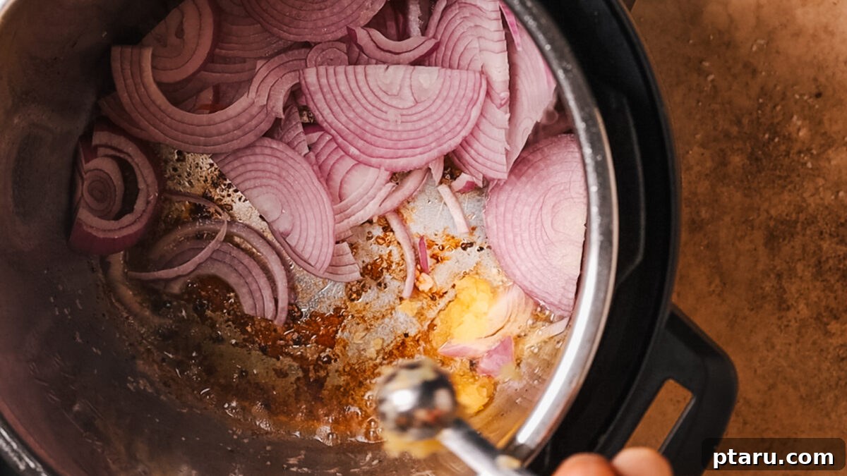 Ultra-Tender Instant Pot Roast Beef 5 Sliced onions and minced garlic sautéing in the Instant Pot