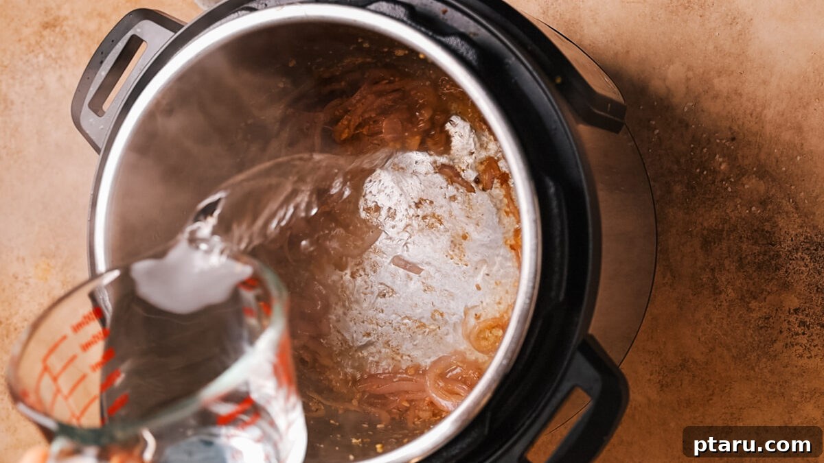 Ultra-Tender Instant Pot Roast Beef 6 Beef broth being poured into the Instant Pot, deglazing the bottom