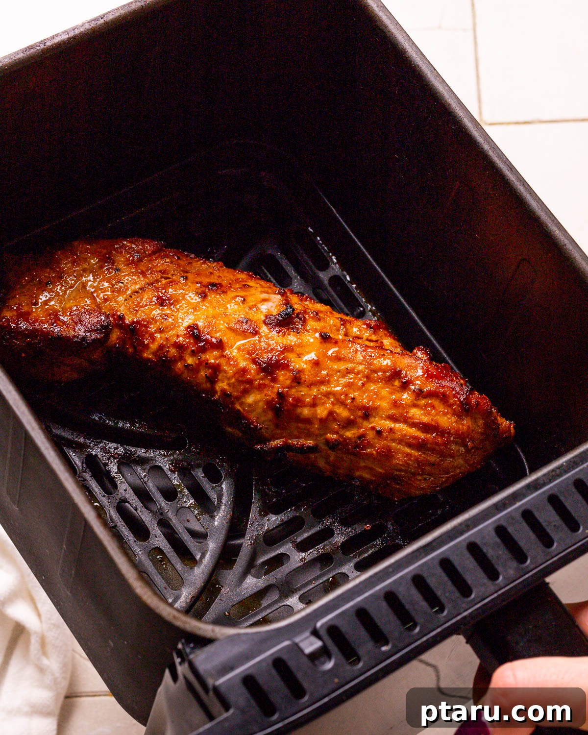 Air Fryer Pork Tenderloin Unbelievably Tender 9 Cooked air fryer pork tenderloin with a beautiful golden-brown crust, fresh out of the air fryer.