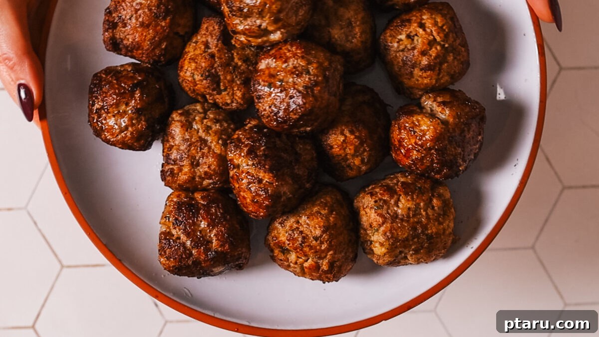 The Secret to Irresistible Meatballs 12 Golden-brown meatballs resting on a plate after frying.