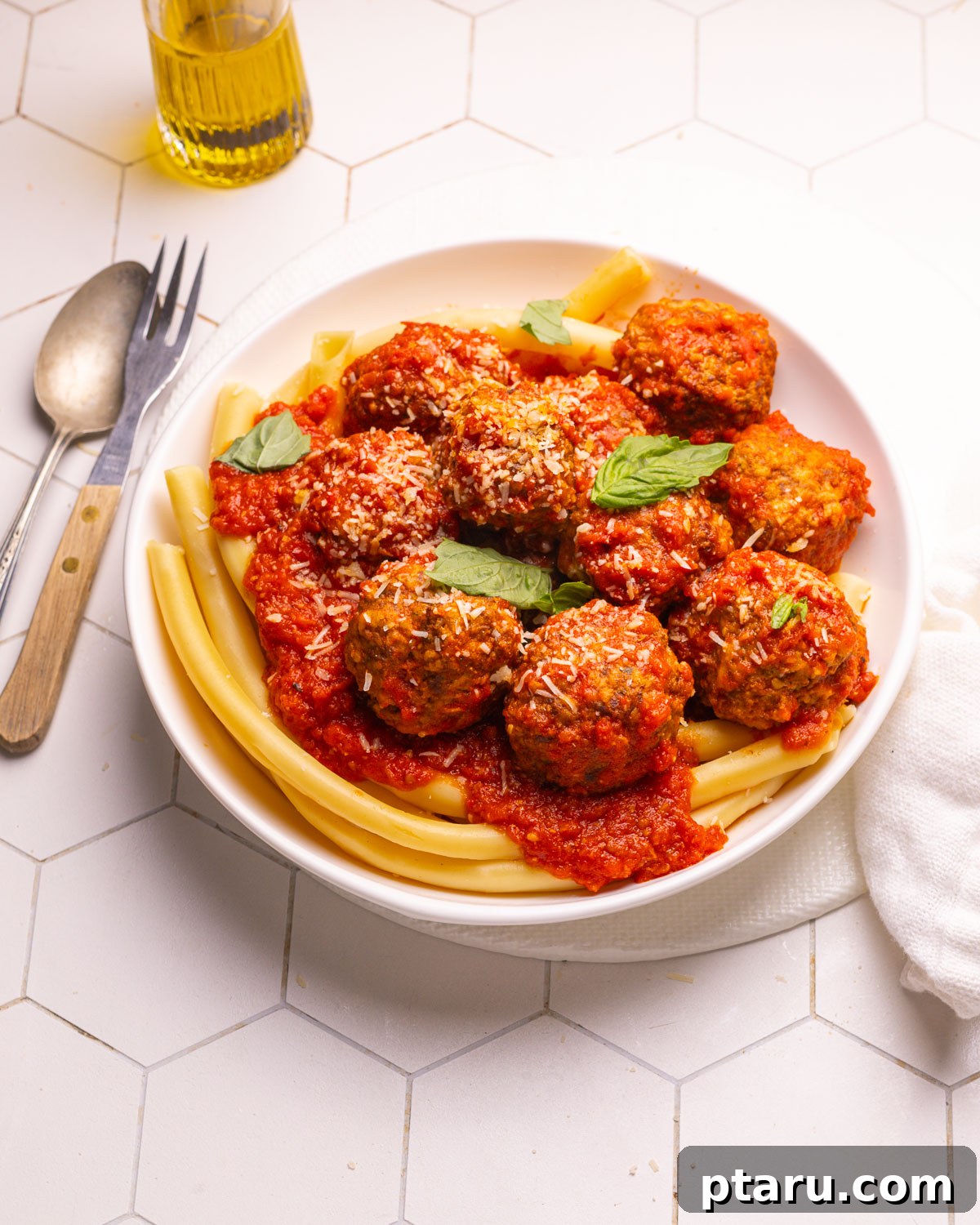 The Secret to Irresistible Meatballs 14 A plated portion of the best meatball recipe with fresh basil, ready to be enjoyed.