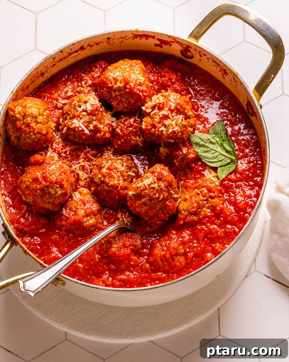 The Secret to Irresistible Meatballs 15 A close-up of a perfectly cooked meatball in rich tomato sauce, with a spoon.