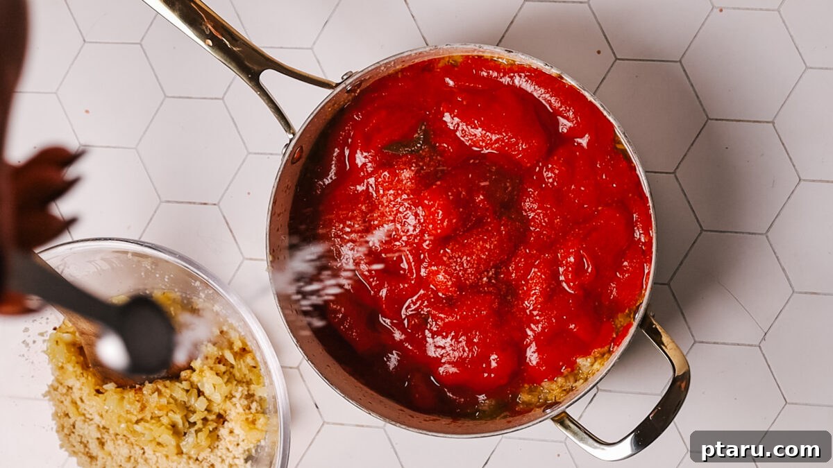 The Secret to Irresistible Meatballs 7 Tomatoes simmering in the pot with the remaining aromatics to make the sauce.