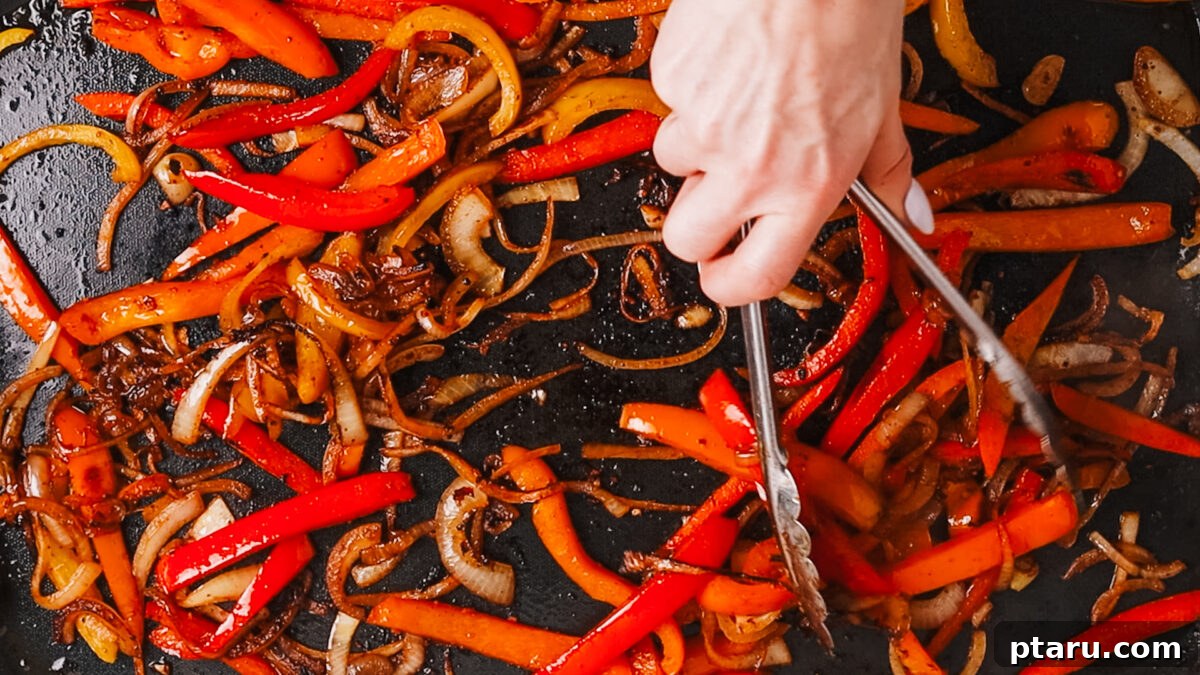 The Ultimate Recipe for Succulent Beef Fajitas 9 Colorful fajita vegetables cooking in a hot skillet, developing a slight char.