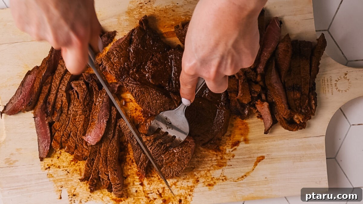 The Ultimate Recipe for Succulent Beef Fajitas 10 Thinly slicing cooked steak against the grain on a wooden cutting board.