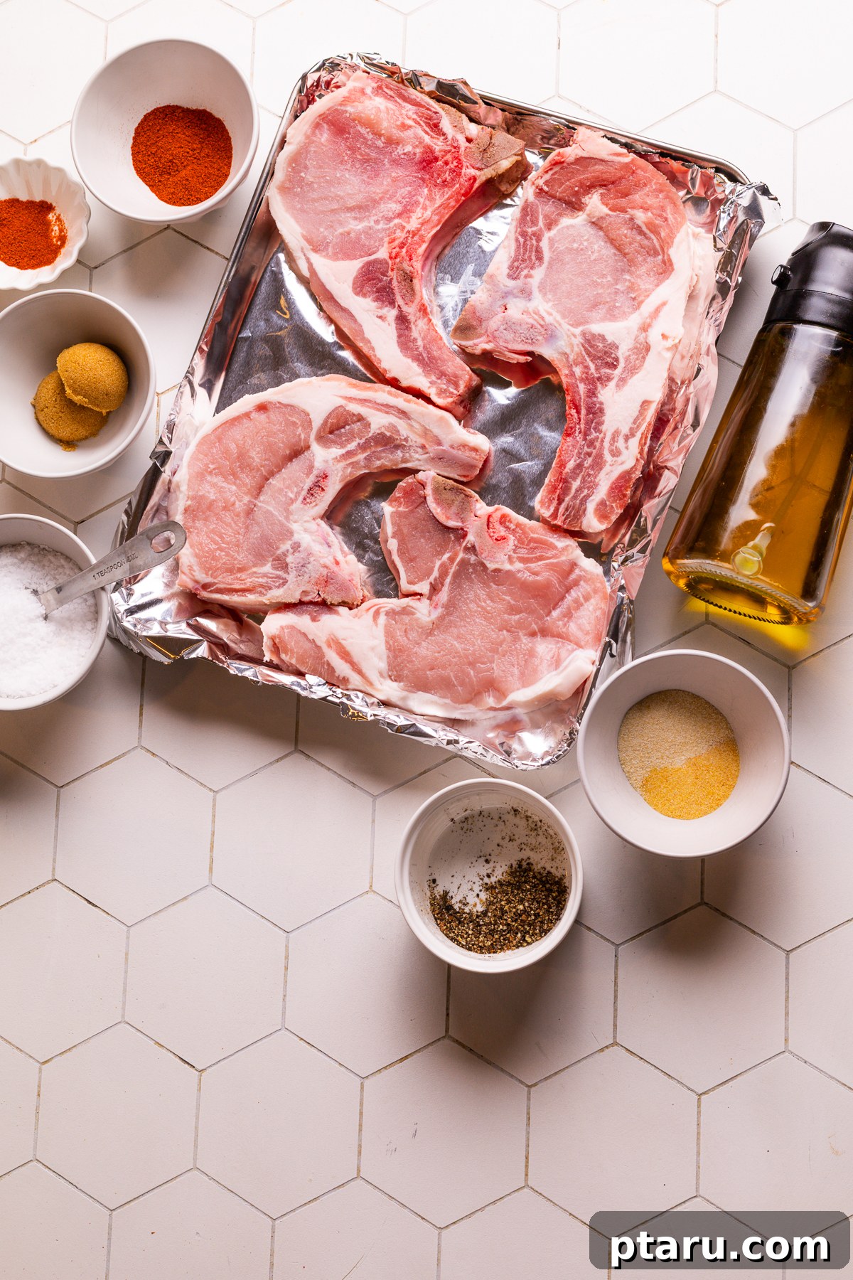 Perfect Oven Baked Pork Chops 3 Ingredients for baking pork chops in oven: spices, olive oil, and pork chops.