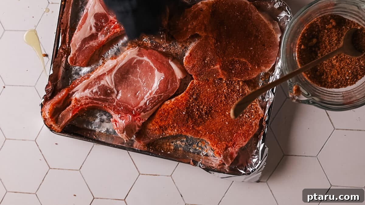Perfect Oven Baked Pork Chops 5 Step-by-step image of pork chops on a baking sheet before broiling.