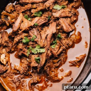 Shredded beef recipe cooking in a crock pot, ready to be served.