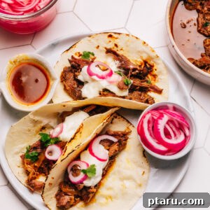 Shredded Beef Tacos, garnished with fresh toppings.