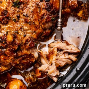 Crockpot pork shoulder in the slow cooker with a spoon, showing its tenderness.