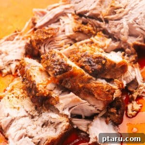Slices of tender slow cooker pork loin on a cutting board, garnished.