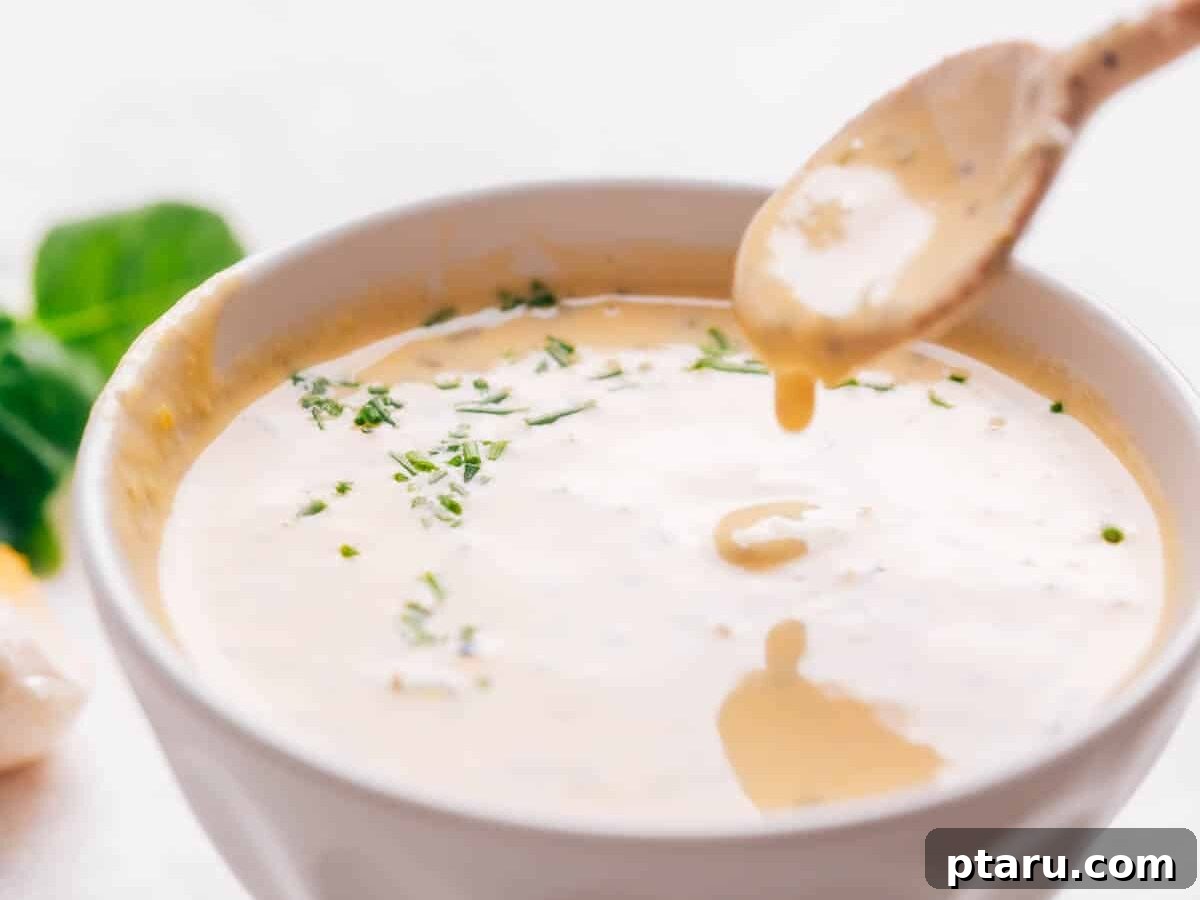 Zesty Lemon Tahini Vinaigrette 2 A bowl of vibrant lemon tahini dressing with a spoon, ready to serve.